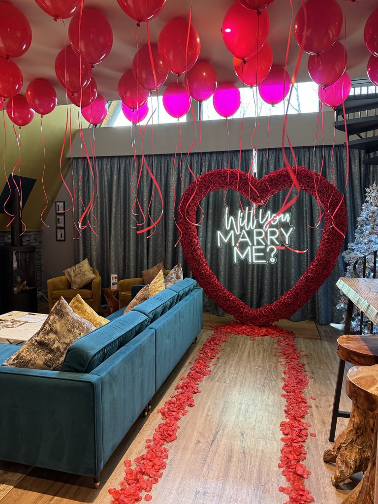 Red petal proposal with red balloons Tree house proposal and hotel room decor from bespoke proposals